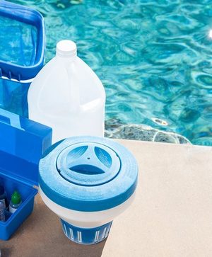 Pool water test kit and chemicals on the deck